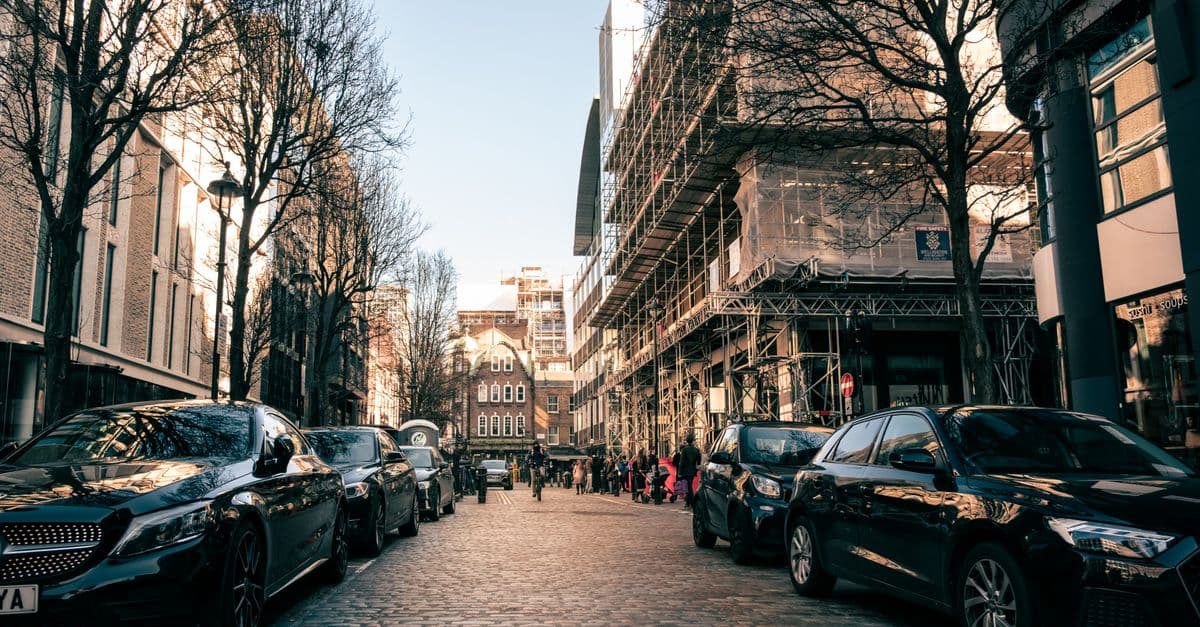 Captivating urban scene in London showcasing architecture and parked cars on a cobblestone street.